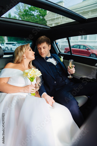 the bride and groom in the back seat of the car. happy newlyweds. 