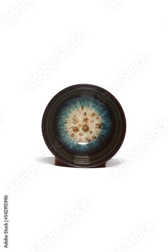 Macro shot of a traditional tea cup decorated with blue tianmu pattern in the Chinese style. The black porcelain bowl for tea ceremony is isolated on a white background. Top view of chinese tea cup. photo