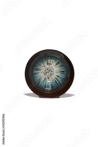 Macro shot of a traditional tea cup decorated with blue tianmu pattern in the Chinese style. The black porcelain bowl for tea ceremony is isolated on a white background. Top view of chinese tea cup. photo