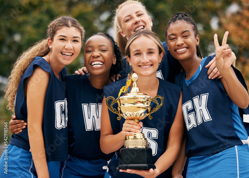 Fototapeta Naklejka Na Ścianę i Meble -  Women, team and winner trophy in fitness game, training match or exercise competition on netball sports field. Portrait, happy smile or sports award for teamwork diversity or friends workout success