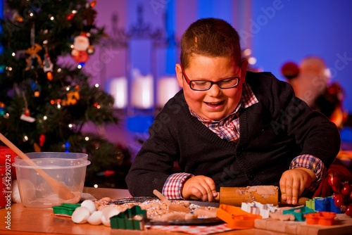 Little Caucasian boy making Christmas cookies with shapes