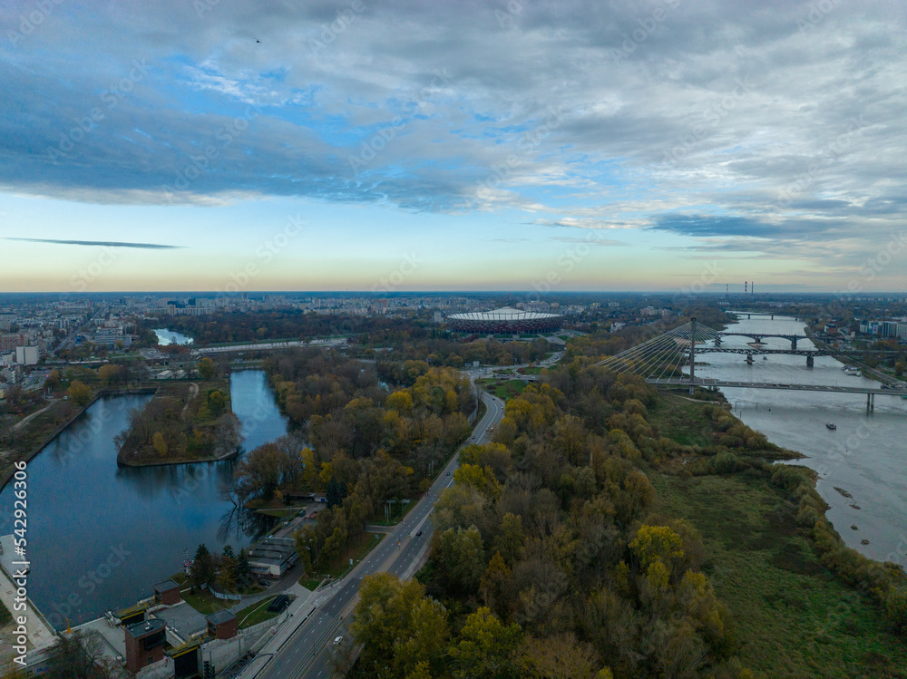 panorama warszawy z rzeką Wisłą i mostami w pochmurny dzień o zachodzie słońca, jesień