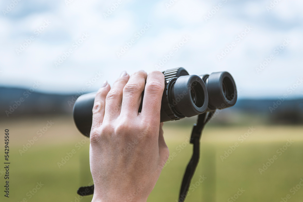 female hand holding a binoculars .