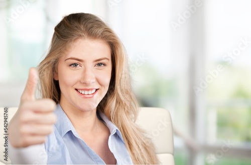 Happy young woman with thumb up posing at home