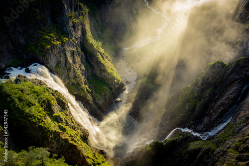 Amazing sunbeams passing through the mist created by the Voringfossen waterfalls, Norway