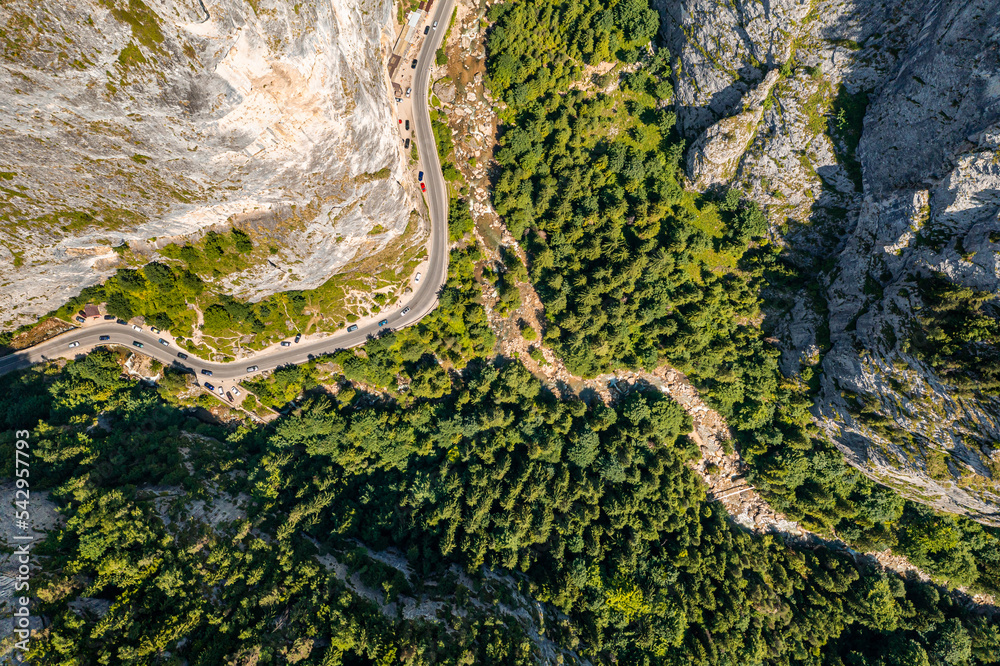 Obraz premium Amazing aerial view with Bicazului Gorges (Cheile Bicazului in Romanian language) landmark in the middle of the mountains. Landscape with trees, forest, curved road and tall rocks. Travel to Romania.