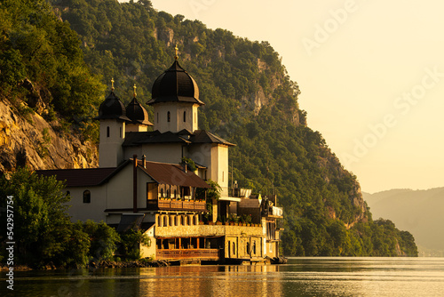 Sunrise over Mraconia Monastery church from Romania at the shore of Danube river. Landmark landscape from Danube Gorges. photo