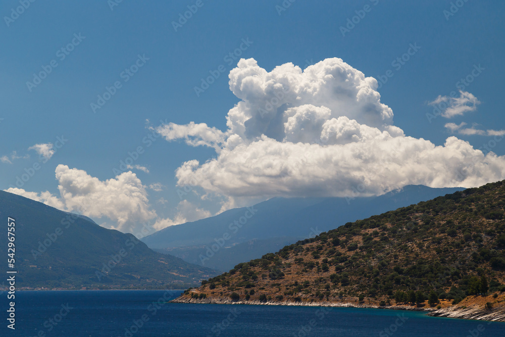 A fantastic view at Cephalonia island, famous and extremely popular travel destination in Greece, Europe. Blue Ionian sea water, hills and beautiful cumulus clouds. A fantastic view at Cephalonia island, famous and extremely popular travel destination in Greece, Europe. Blue Ionian sea water, hills and beautiful cumulus clouds.