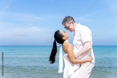 A couple of men and women of different nationalities go to the beach and walk happily on the beach together. on summer vacation