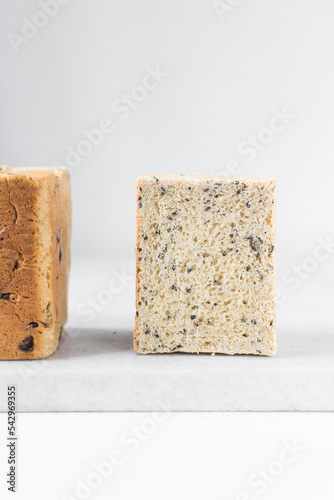 Black sesame seed bread on a white chopping board, poppy seed bread, pullmans loaf, sandwich loaf photo