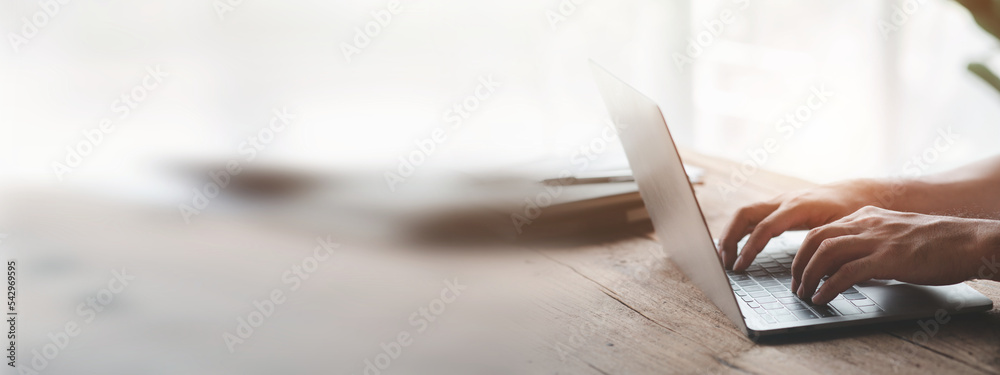 Person typing on laptop keyboard, businessman working on laptop, he is