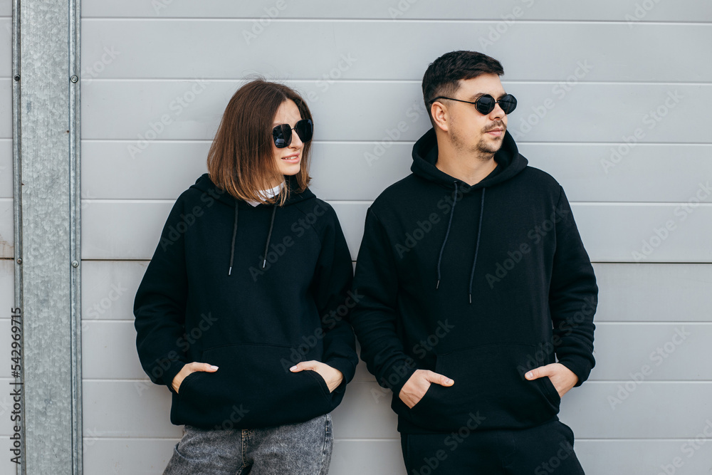 Young adult men and woman in glasses and black hoodies Stock Photo