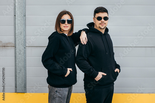 Young adult men and woman in glasses and black hoodies 