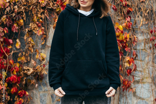 Young woman in glasses and black hoodie