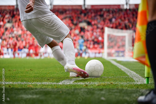 Obraz na płótnie Footballer takes the corner. Detail of player's legs and the ball during soccer match. w salonie