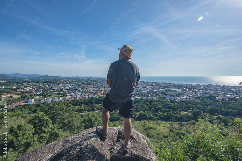 Asian fat man stand on the rock  at Khao hin lek fai view point.Khao Hin Lek Fai is a place to see a spectacular view of the entire town.Also know as khao radar in local people.