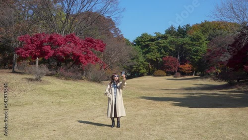 woman walking owoman who takes a selfie in front of autumn leavesn a path tinted with autumn leaves photo