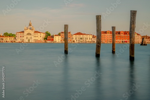 Wooden pilings on the water's surface with beautiful buildings in the background. Venice, Italy. photo