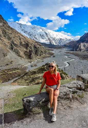A young girl on the background of the Darial gorge, Kazbegi district, Mtskheta-Mtianeti region, Georgia 2019.