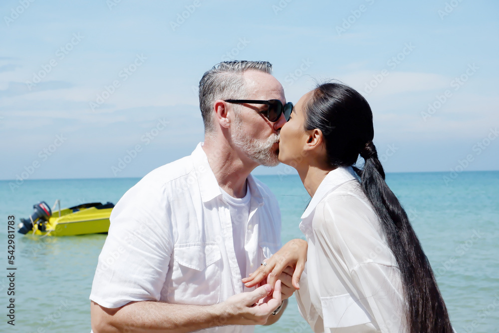 Young couple standing kissing on the beach. Couple concept.