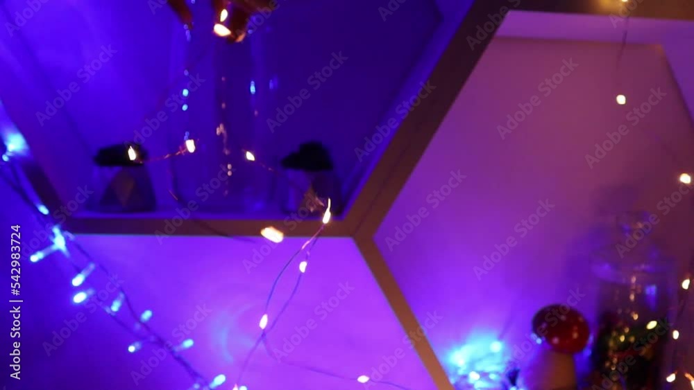 Flashing garland in hand. Beautiful decoration of the interior of the house for the New Year Flashing garland in hand. Beautiful decoration of the interior of the house for the New Year
