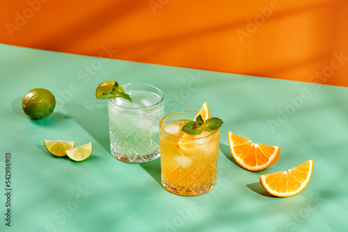 Multi-colored cocktails in glasses of different shapes on colored backgrounds with hard shadows