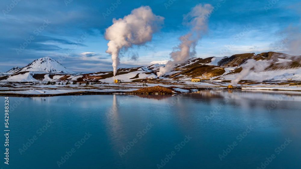 aerial view on geothermal plant over blue lake with refelction during winter with snow in iceland