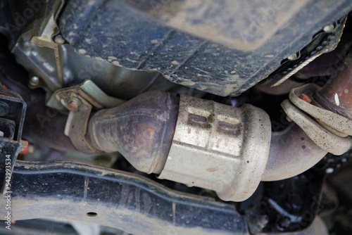 Closeup catalytic converter of a modern car bottom view. Shallow focus. photo