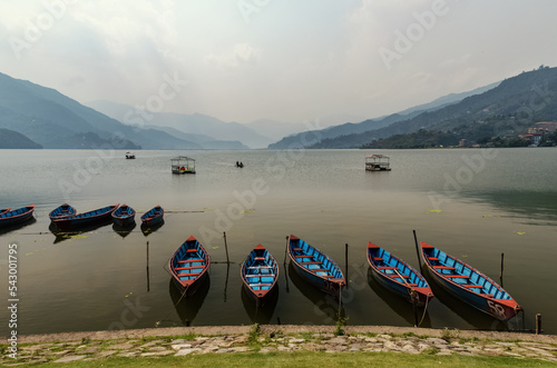 Blue boats on Lake Phewa Pokhara Nepal at sunset 