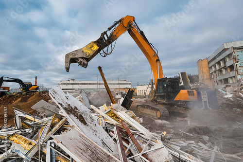 Excavator with hydraulic press breaks concrete leftovers