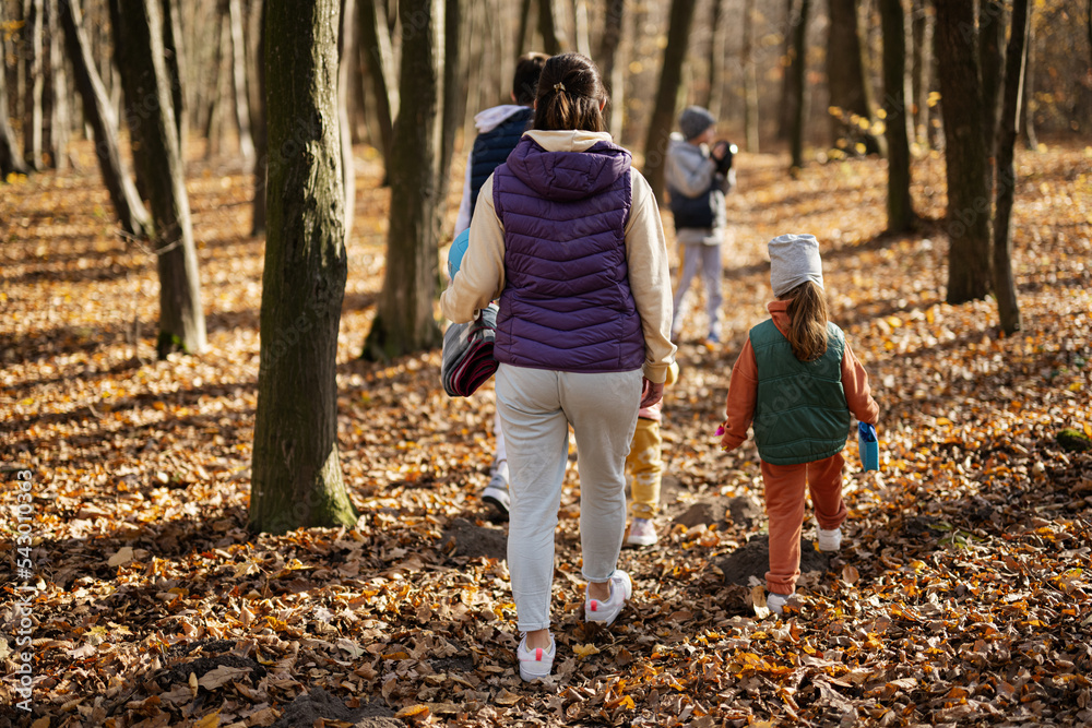 Mother with kids in family leisure at autumn activity in forest. Mother with kids in family leisure at autumn activity in forest.