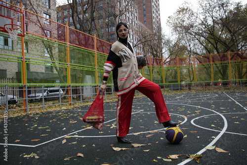 fashion style woman on the basketball sport playground with ball