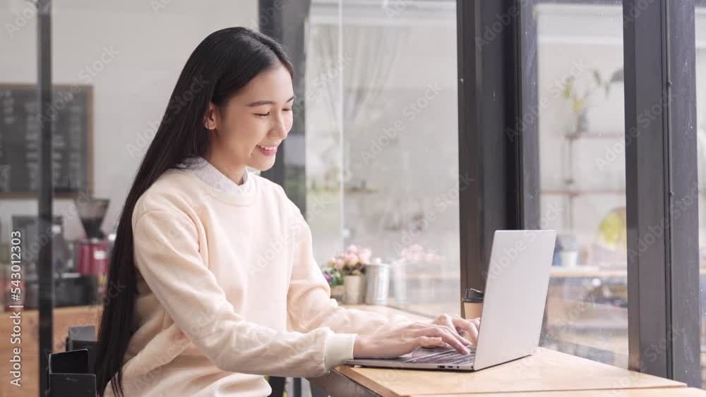 Asian female student Sit and work in a cafe. online learning, work from home Asian female student Sit and work in a cafe. online learning, work from home