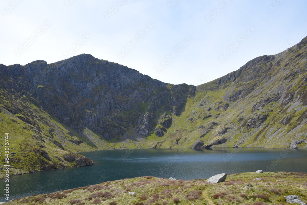 a view looing down in the crater of Cadair Idris with a mountain view behind it