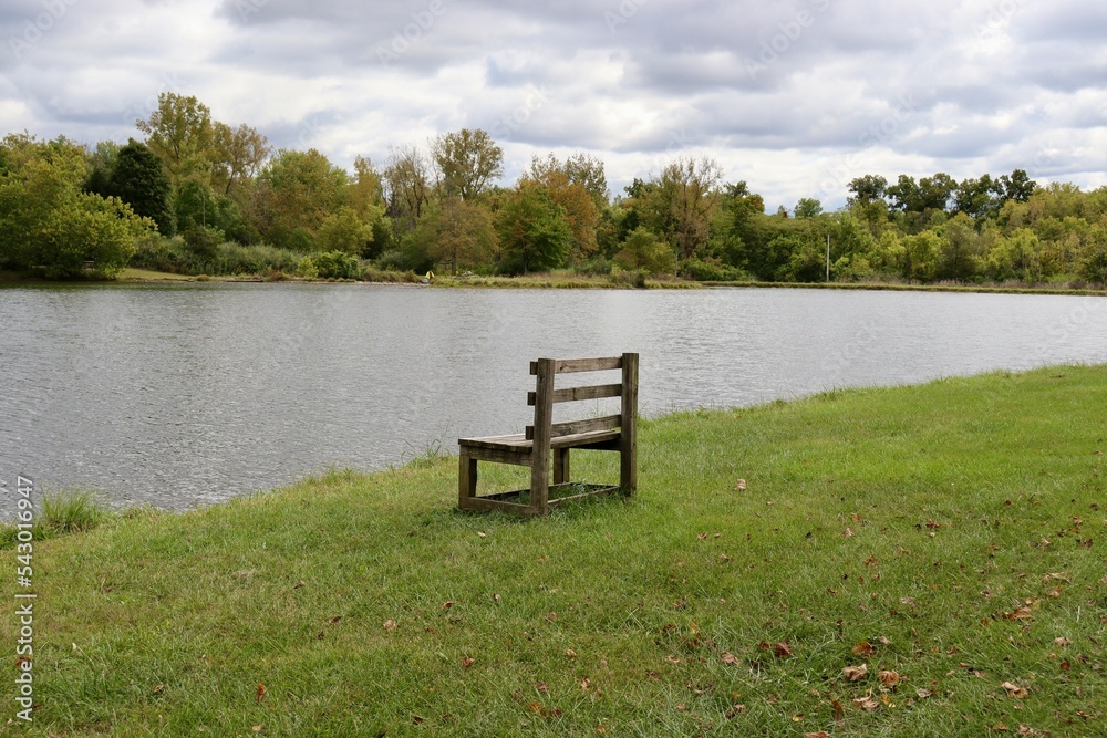 Fototapeta premium The empty wood bench by the lake in the countryside.