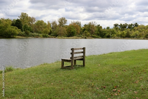 The empty wood bench by the lake in the countryside.