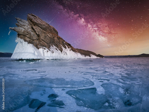 Landscape of Mountain with natural breaking ice and milky way in frozen water on Lake Baikal, Siberia, Russia.