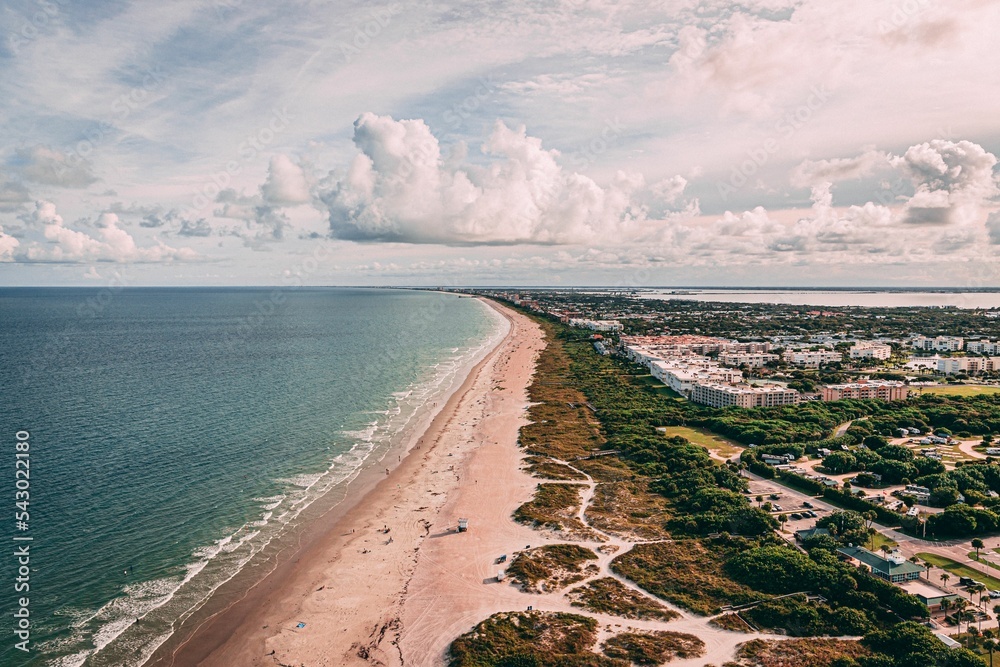 Fototapeta premium Drone shot of Cape Canaveral cityscape by the beach under cloudy sky in Florida
