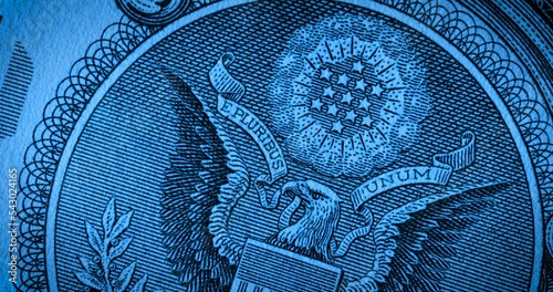 Фотография Macro shot of the back side of a one dollar bill with stars and an eagle in blue soft light