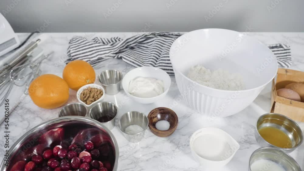 Step by step. Ingredients to bake cranberry muffins on a marble kitchen surface. Step by step. Ingredients to bake cranberry muffins on a marble kitchen surface.