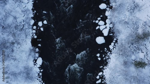 arctic rapid river in northern finland in lapland during winter time frozen forest with snow and dark water drone video great intro sequence co2 sustainable life