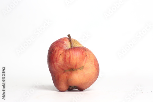 Concept of ugly food - red apple on white background