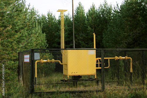 Gas distribution point, fenced with a grid in the forest. The concept of the energy crisis, lack of fuel. Translation flammable, gas