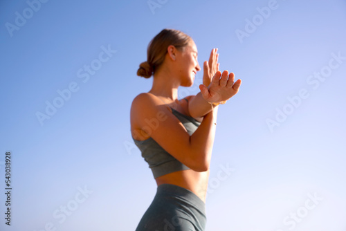 Woman doing sport and yoga exercices on the beach