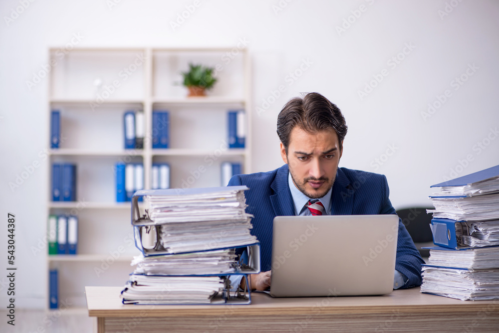 Fototapeta premium Young male employee and too much work in the office