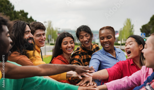 Fényképezés Happy young multiethnic people stacking hands in the city