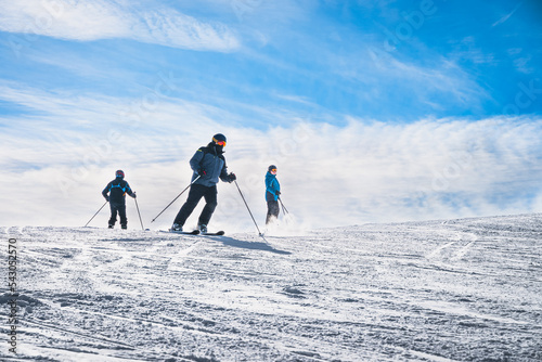 Three man skiing down the ski slope or piste in Pyrenees Mountains. Winter ski holidays in El Tarter, Grandvalira, Andorra