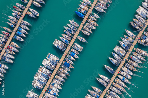White Yacht and boats parking in mediterranean sea pier. Aerial top view by drone, concept travel cruise