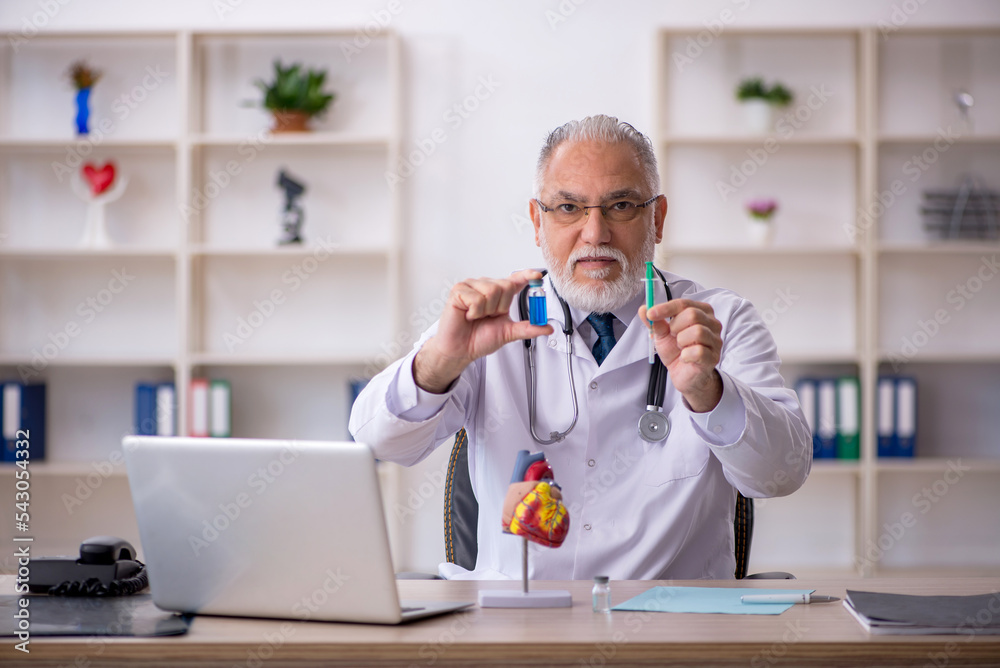 Old male doctor cardiologist working in the clinic Old male doctor cardiologist working in the clinic