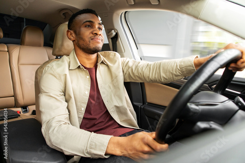 Foto Portrait of a serious african american man driving a car with a beige interior